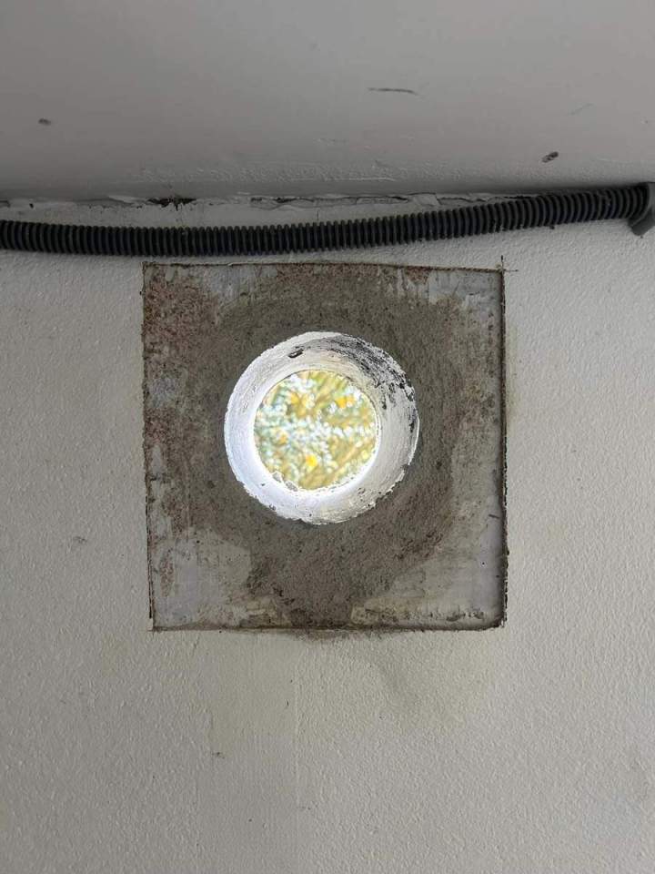 Hublot dans un mur en béton enduit Josselin