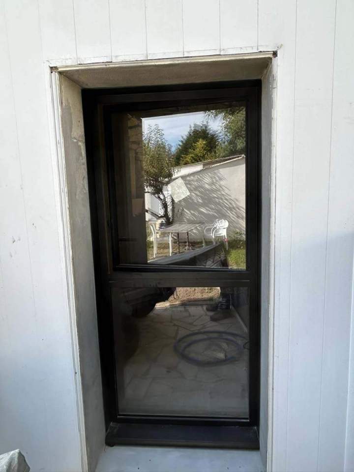 Fenêtre à auvent simple en aluminium, installée dans une ouverture murale blanche Josselin