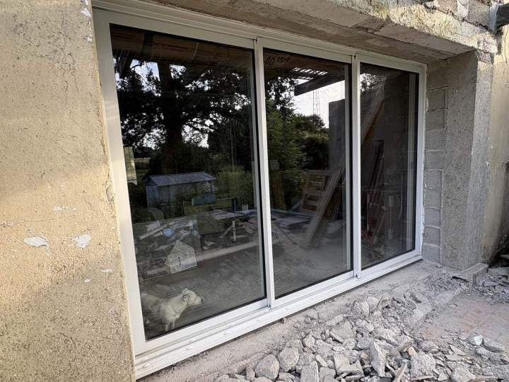 Porte-fenêtre coulissante en verre dans un mur extérieur ouvert Josselin